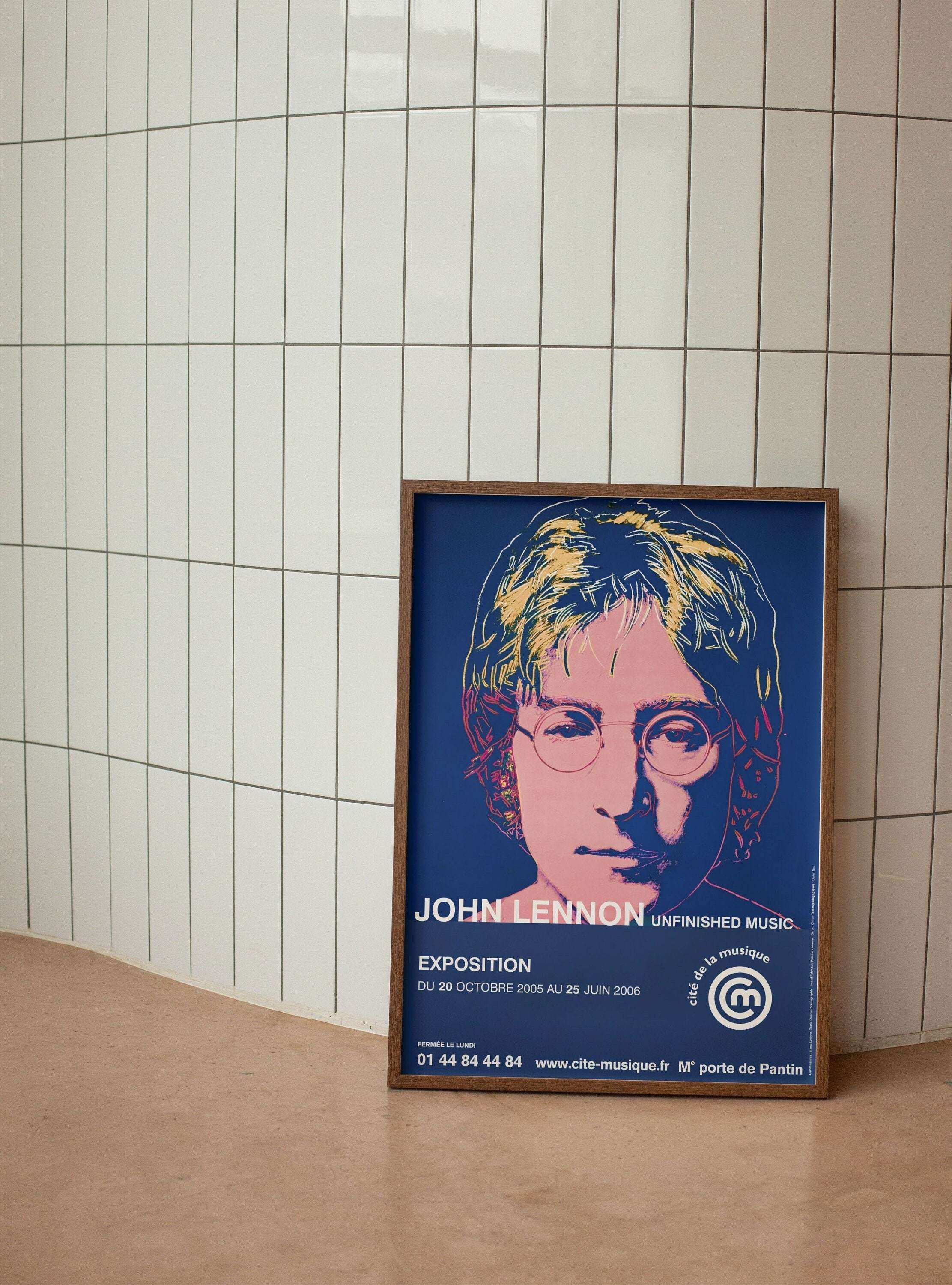 The poster features a pop art photo of John Lennon in the center, looking directly at the viewer. He is wearing a round-neck white T-shirt and has his hair down.